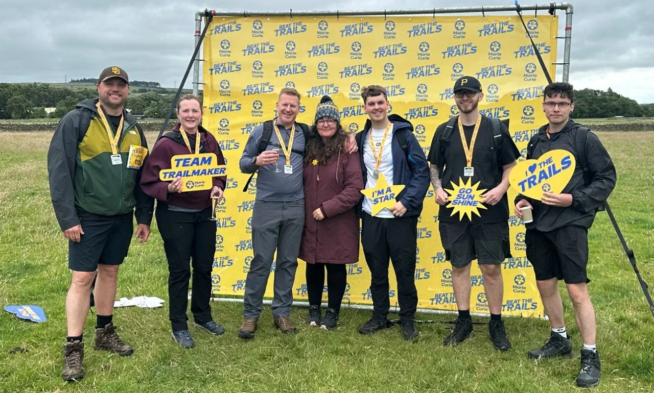 Besseges team members celebrating at the finish of the 11-mile Hadrian's Wall challenge.